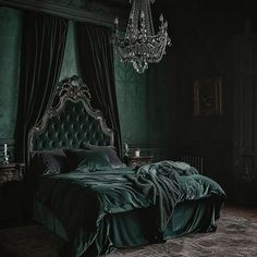 a bedroom with green walls and a chandelier hanging from the ceiling