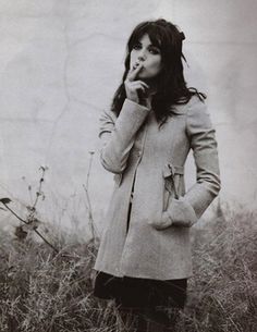 black and white photograph of a woman standing in tall grass with her hand on her mouth