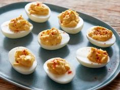 deviled eggs with bacon and parsley on a blue plate, ready to be eaten