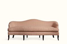 an upholstered couch with wooden legs and a patterned fabric on the back, against a white background