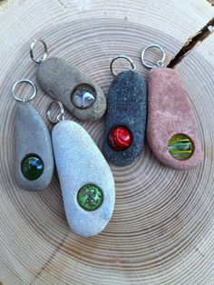 four different colored rocks sitting on top of a wooden table next to a pair of scissors