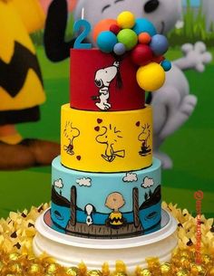 a three tiered cake decorated with peanuts and charlie the pooh characters on it