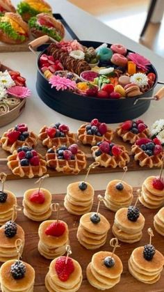 a table topped with lots of waffles covered in fruit