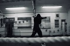 a man standing in a boxing ring holding a punching glove