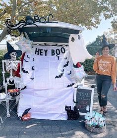 a woman standing next to a car decorated for halloween