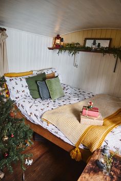 a bed sitting in the corner of a room next to a christmas tree