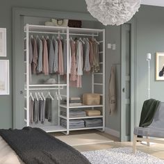 a white closet with clothes hanging on it