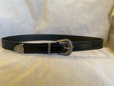 This is a 30mm wide black leather be (also available in Brown leather) with a three piece Weston style buckle set and a Zig Zag emboss on the edges, just add a note to seller with the waist size you would like, Waist size is from the buckle end of the leather to the middle hole then you will have three holes bigger and three holes smaller Classic Adjustable Hand Tooled Belt, Classic Adjustable Hand-tooled Belt, Black Leather Belt Buckles With Antique Buckle, Black Leather Belt Buckle With Antique Design, Classic Hand Tooled Leather Belt Buckles, Classic Black Concho Belt Buckles, Formal Black Antique Belt Buckle, Formal Adjustable Engraved Belt, Engraved Leather Belt Buckles, Adjustable