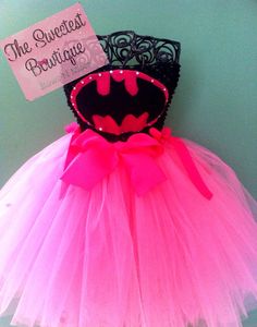 a pink tutu skirt with a batman mask on it and a sign that says the sweetest boutique