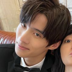 a young man and woman are posing for a photo in tuxedo shirts, bow ties, and black hair