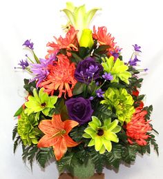 a vase filled with lots of different colored flowers