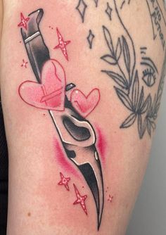 a woman's thigh with tattoos on it and a knife in the shape of a heart