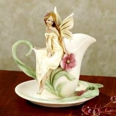 a porcelain figurine sitting on top of a saucer with flowers in it