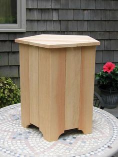 a wooden box sitting on top of a table next to a potted planter