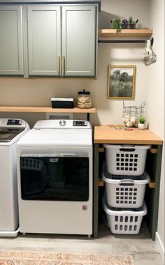 a washer and dryer in a small laundry room with cabinets above the washer