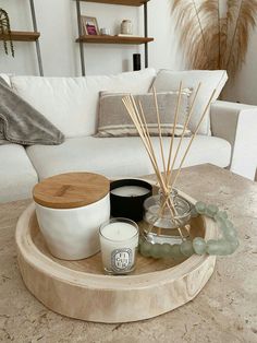 a living room with a white couch and candles on the coffee table in front of it