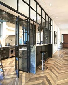 an open kitchen with marble counter tops and stainless steel barstools, as well as wooden flooring