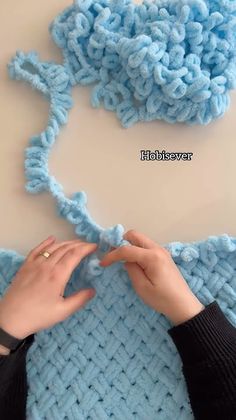 two hands crocheting the ends of a blue knitted blanket with text overlay that reads, how to crochet