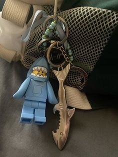 there is a keychain with a shark on it next to some other items