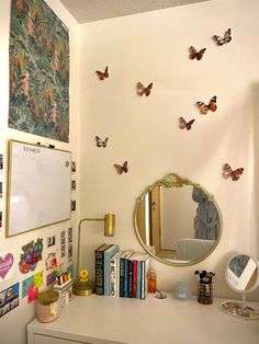 a white desk topped with a mirror and lots of butterflies on the wall