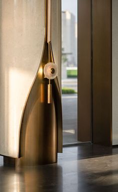 a large metal object sitting in the middle of a floor next to a building with glass doors