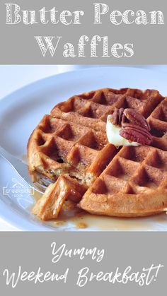 a white plate topped with waffles covered in syrup and pecans on top