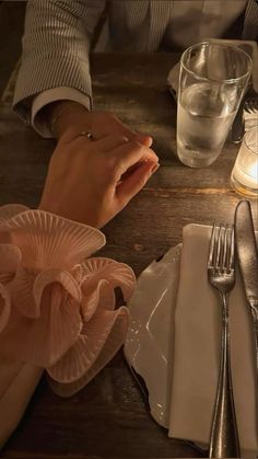 two people sitting at a table with silverware and napkins in front of them