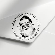 a santa claus sticker is on the back of a white envelope with black lettering