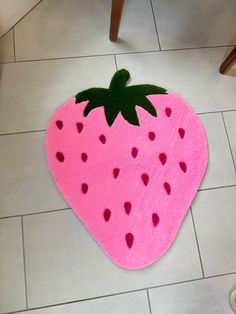 a pink rug with a green strawberry on it