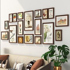 a living room filled with lots of framed pictures on the wall next to a couch