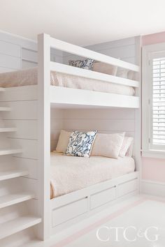 a white bunk bed sitting in a bedroom next to a window with shutters on the windowsill