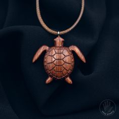 This turtle pendant is made from rare Bubinga wood, making it unique and particularly attractive. Each pendant is handcrafted with high attention to detail and precision, which adds to its uniqueness and elegance. The turtle, which is a symbol of wisdom, stability, and longevity, makes this pendant a perfect gift for those who strive for success and stability in life.    [CARE] The pendant is sealed with two or more layers of wood oil in order to protect the wood against moisture and the environ Wooden Pendant Necklace For Gift, Handmade Mahogany Jewelry Gift, Handmade Mahogany Jewelry For Gift, Handmade Mahogany Necklace For Gift, Mahogany Handmade Jewelry For Gift, Carved Natural Wood Necklaces, Mahogany Wooden Beads Jewelry For Gifts, Natural Wood Pendant Necklace, Strive For Success