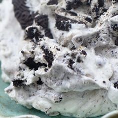 an ice cream dessert with oreo cookies and cream frosting on a blue plate