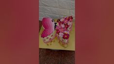 two decorated cakes sitting on top of a yellow table cloth covered in pink and white frosting