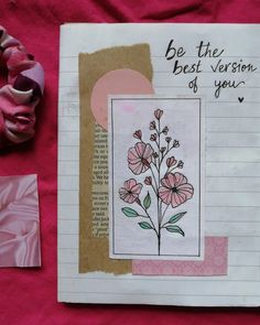 a piece of paper with flowers on it next to some pink ribbon and other items