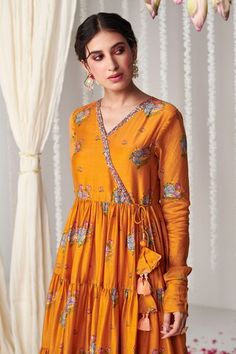 Orange long sleeves tiered angarkha style anarkali with all over bagicha print and hand embroidered neckline. Paired with a lycra churidar and a printed dupatta. - Aza Fashions Transitional Yellow Anarkali Set With Long Sleeves, Yellow Long Sleeve Anarkali Set For Transitional Season, Transitional Yellow Long Sleeve Anarkali Set, Yellow Anarkali Set With Printed Motifs And Long Sleeves, Designer Long Sleeve Anarkali Set With Printed Motifs, Long Sleeve Chanderi Anarkali Set With Printed Motifs, Bollywood Style Long Sleeve Choli With Printed Motifs, Festive Long Sleeve Choli With Printed Motifs, Yellow Long Sleeve Choli For Eid