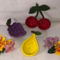 there are some fruit and flowers sitting on the table together, including one yellow pear