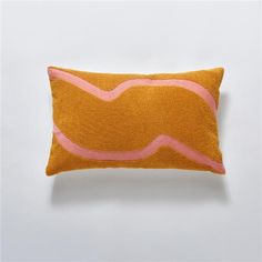 an orange and pink pillow sitting on top of a white wall