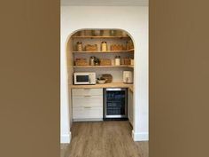 a kitchen with an oven, microwave and cabinets on the wall in it's corner