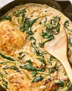 a skillet filled with chicken and spinach covered in gravy