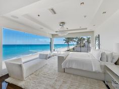 a bedroom with a large bed and ocean view from the room's glass windows