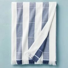 the blue and white striped towel is folded up on top of a light blue wall