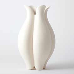 two white vases sitting next to each other on a white surface with no one around them