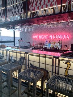 the bar is decorated with neon lights and chairs