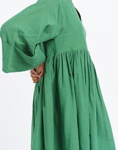 Oversized midi dress in mood elevating basil green color is tailored from handwoven cotton fabric by women artisans of India's western region. Designed for year-round utility, finished with subtle gathers at the waist to give the boxy fit additional contour. This dress would be ideal for transition weather and semi-formal settings. Green Oversized Cotton Maxi Dress, Oversized Green Cotton Maxi Dress, Green Knee-length Midi Dress With Gathered Sleeves, Green Cotton Midi Dress For Daywear, Green Billowy Maxi Dress, Green Cotton Dress With Gathered Sleeves, Green Smock Midi Dress, Oversized Green Midi Dress, Billowy Green Dress