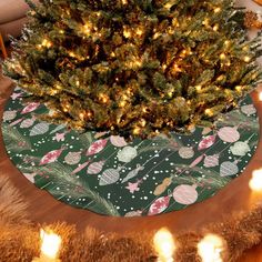 a christmas tree with lights around it on a round rug in the middle of a room