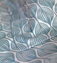 a close up view of a blue and white pattern on an unmade bed sheet