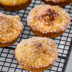 several sugared donuts sitting on a cooling rack