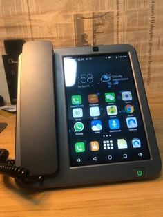 an open cell phone sitting on top of a wooden table next to a charger