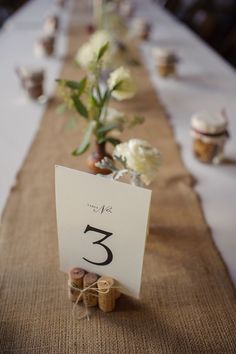 the table is set up with white flowers and place cards for each guest to sit on